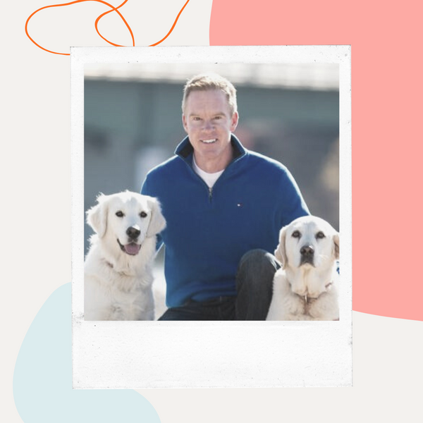Dr. Blake Hawley kneeling with two golden retrievers