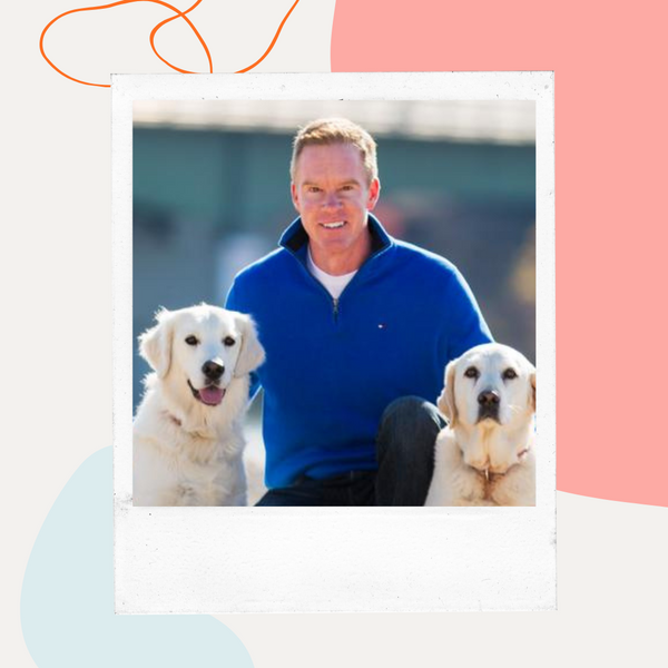 Dr. Blake Hawley kneeling with two golden retrievers