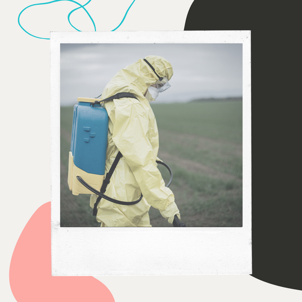 Farm worker in protective gear spraying a field