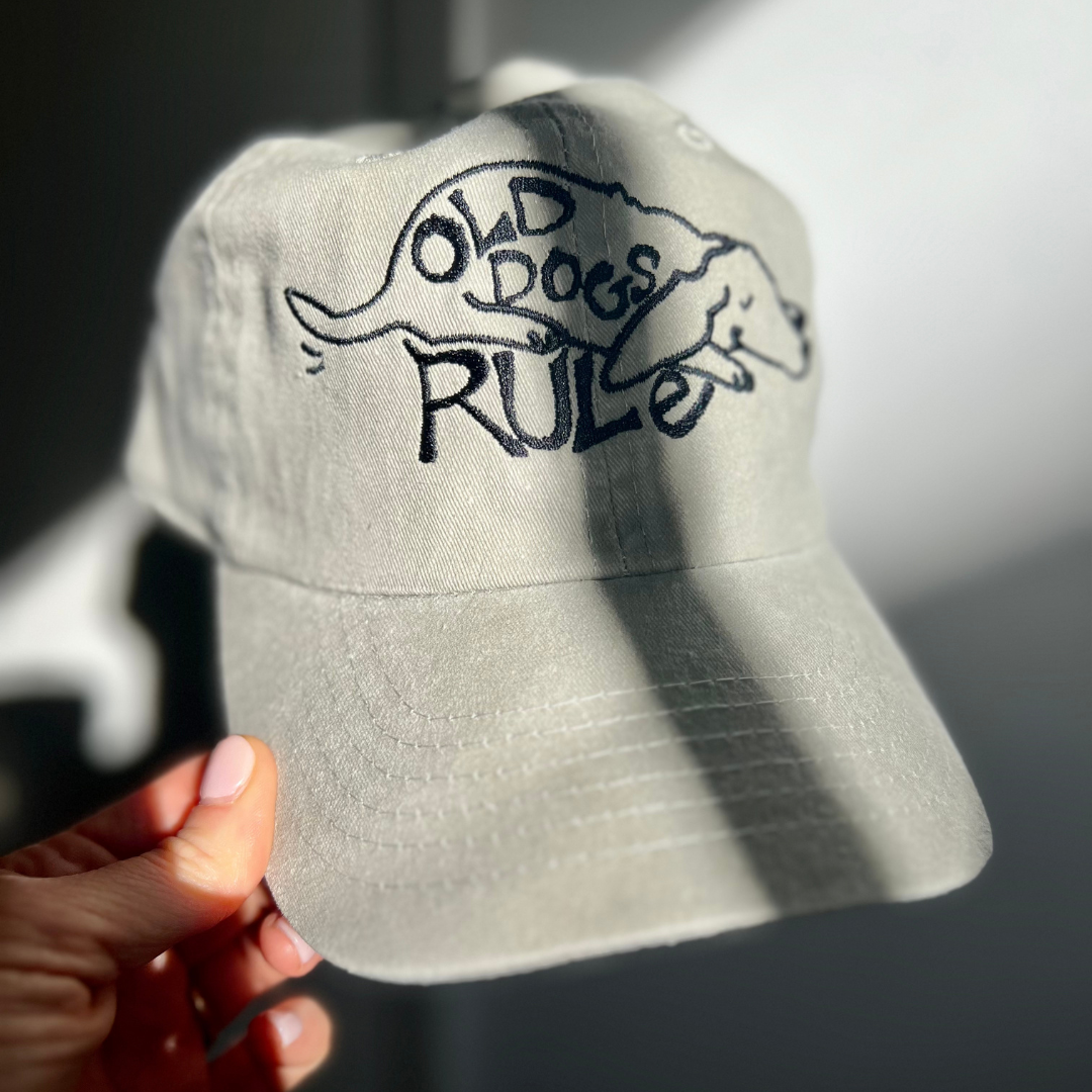 Close-up of the Old Dogs Rule embroidery on the beige Petaluma cap